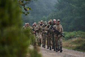 An elite military unit, led by a major, confidently parades through dense forest, showcasing precision, discipline, and readiness for high-risk operations photo