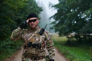 A dedicated soldier salutes his elite unit, showcasing camaraderie and readiness for the most perilous military operations photo