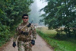 Elite soldier exudes focused determination and readiness, geared up for a perilous military operation, capturing the essence of courage and professionalism in the face of imminent danger photo