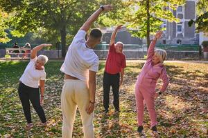 A group of seniors follows a trainer, engaging in outdoor exercises in the park, as they collectively strive to maintain vitality and well-being, embracing an active and health-conscious lifestyle in photo