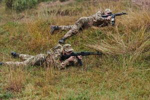 Elite soldiers stealthily maneuver through the dense forest, camouflaged in specialized gear, as they embark on a covert and strategic military mission photo