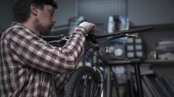Bicycle mechanic works in cycle repair and adjustment workshop. Bike technician twists bike stem and handlebars with special tool. Repairman using a tool to fit the handlebar bolts. Bicycle service. video