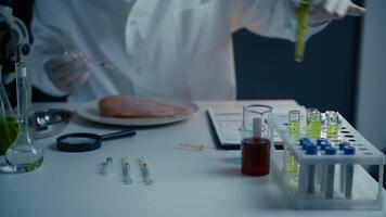 Male nutrition expert testing food products in laboratory. Lab assistant testing GMO chicken. Putting sample of chemical with injection in to test chicken meat. Genetically modified food, syringe. video