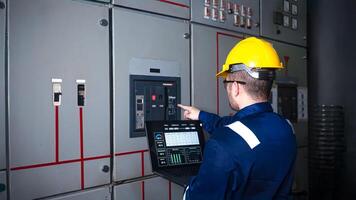 Electrical engineer check the operation of the main electrical control panels system on laptop photo
