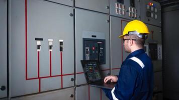 Electrical engineer check the operation of the main electrical control panels system on laptop photo