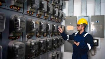eléctrico mantenimiento ingeniero es comprobación .electricidad metro, principal distribución tablero y escribir abajo valor de electricidad en un portapapeles foto