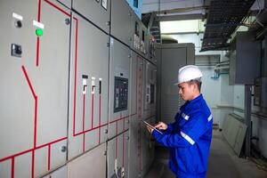 electrical engineer check the operation of the main electrical control panels photo