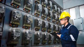 eléctrico mantenimiento ingeniero es comprobación .electricidad metro, principal distribución tablero y escribir abajo valor de electricidad en un portapapeles foto