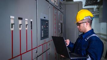 Electrical engineer check the operation of the main electrical control panels system on laptop photo