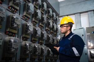 Electrical maintenance engineer is checking Electricity meter, main distribution board and write down value of electricity on a clipboard photo
