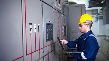 Electrical engineer check the operation of the main electrical control panels system on laptop photo
