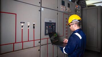 Electrical maintenance engineer is checking .Electricity meter, main distribution board and write down value of electricity on a laptop photo