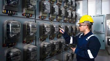 eléctrico mantenimiento ingeniero es comprobación electricidad metro, principal distribución tablero y escribir abajo valor de electricidad en un portapapeles foto