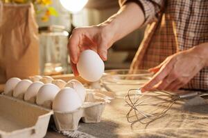 Hand taking out egg from egg carton in kitchen photo