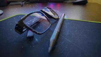 A pair of glasses and a pen on a desk photo