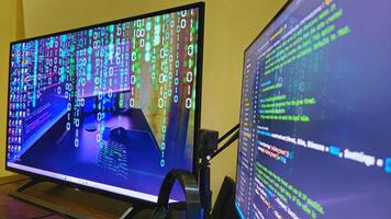 Two large monitors with code on them photo