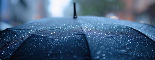Close-up of black umbrella with raindrops on its surface during rainy weather photo