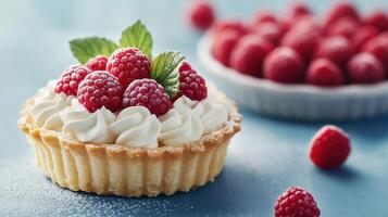 Close-up of bright raspberry tart with cream and fresh raspberries on a table in natural light photo