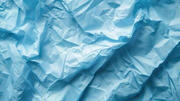 Close-up of wrinkled blue paper texture, ideal for scrapbooking and crafting. Top view photo