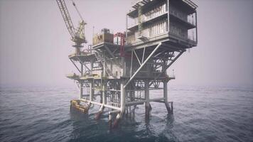 Old oil platform standing in calm waters under a cloudy sky at dawn video