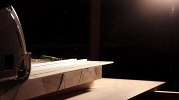 Close-up of a man cuts a wooden plank with an electric circular saw in a workshop. Cutting a piece of wood on a circular saw in backlight. Ideal topics related carpentry, efficient sawing techniques video