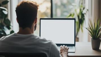 Over shoulder shot of a young man using computer laptop photo