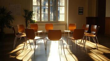 A circle of empty chairs stands in a bright room bathed in sunlight photo