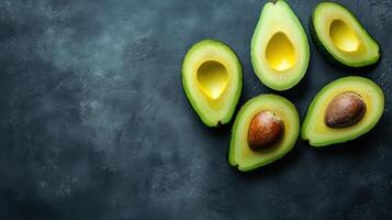 Aerial view of halved avocados on a dark background photo