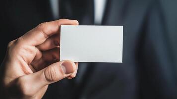 A hand holding a blank business card in a formal setting photo