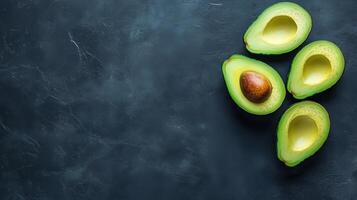 Aerial view of halved avocados on a dark background photo