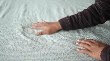 A detailed closeup view featuring hands resting gently on a richly textured fabric surface video