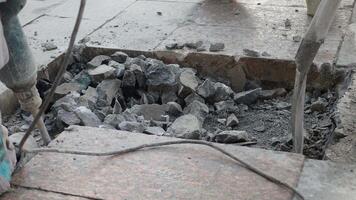A group of workers using a jackhammer to break and remove concrete sections on a construction site video