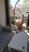 Enjoying a Relaxing Afternoon in a Stylish and Comfortable Hanging Chair on a Beautiful Balcony video
