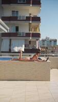 Enjoying a relaxing time by the poolside with my laptop in a beautiful sunny setting video