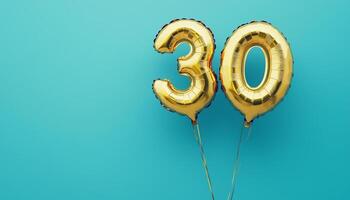 Number 30 Gold balloon metallic shiny copy space isolated blue background photo
