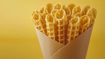 Waffle roll snack crispy wafer stick for kids on paper wrap package solid background photo