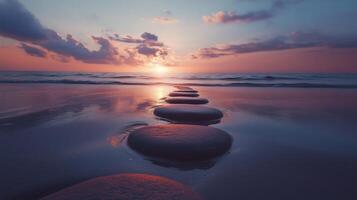 Stepping grey stones with texture forwarding in beach sand and ocean water with sunset sky photo