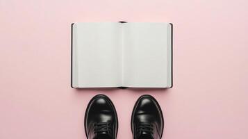 Blank white book open white paper and a pair black shoes top of view pink background photo