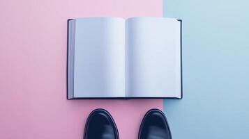 Blank white book open white paper and a pair black shoes top of view pink background photo