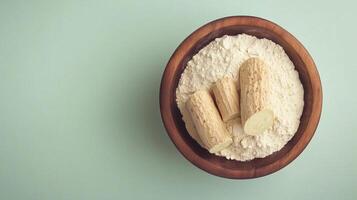 Cassava flour on brown wooden bowl and some fruits for baking, gluten free copy space photo