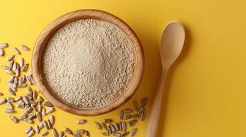 Sunflower flour on brown wooden bowl and some seeds for baking, gluten free copy space photo