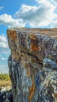 Edge rock cliff in mountain with blue sky and cloud vertical story nature background photo