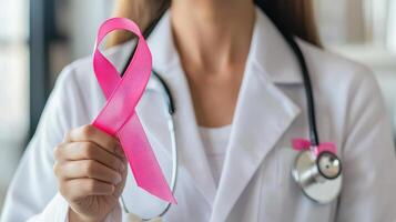 A woman in a white lab coat holding a pink ribbon photo