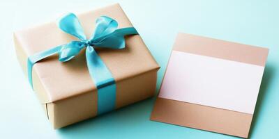 Gift box with blue ribbon and blank card on turquoise background photo