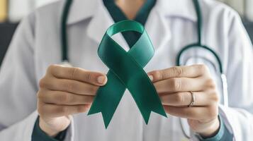 A doctor holding a green ribbon in front of him photo
