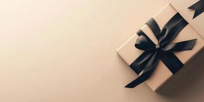 A black gift box with a bow on a beige background photo