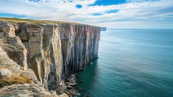 A cliff with a blue sky and water photo