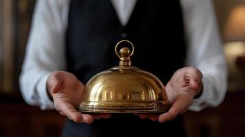 A waiter holding a bell in his hands photo