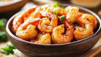 A bowl of shrimp with chopsticks and a spoon photo