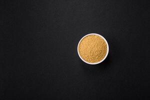 Wheat porridge couscous grains on a dark concrete background photo
